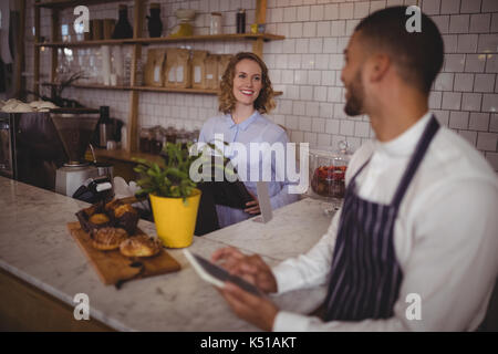 Lächelnden jungen Kellner und Kellnerinnen stehen an der Theke im Café Stockfoto