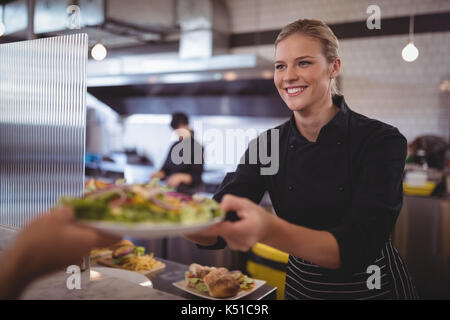 Attraktive junge Frau Koch, Griechischer Salat frisch im Coffee shop Kellner Stockfoto