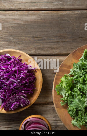 Ansicht von oben von frischen Grünkohl Blätter mit Rotkohl in Holz- Platten Stockfoto