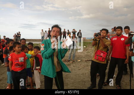 Banda Aceh, Indonesien. 07 Sep, 2017. Ein Student liest ein Gedicht über die rohingyas Minderheit, hat heftig auf die militärische von den letzten Tagen unterzogen worden. Die Lesung des Gedichts ist Teil der theatralischen Aktion der Verteidigung der muslimischen Minderheit Rohingya durch Dutzende von Studenten in der Provinz Aceh, Indonesien. Credit: Abdul Hadi Firsawan/Pacific Press/Alamy leben Nachrichten Stockfoto