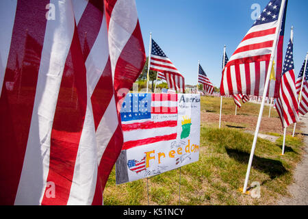 Bild eines Kindes eine amerikanische Flagge wird durch tatsächliche Flags zu einem Memorial Day patriotischen Anzeige in einem Newport Beach, CA, Park umrahmt. Stockfoto