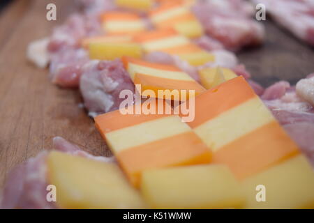Rohes Fleisch mit Käse auf einem Holzbrett Stockfoto