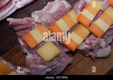 Rohes Fleisch mit Käse auf einem Holzbrett Stockfoto