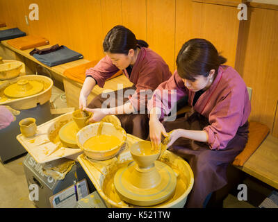 Yokosuka, Japan - Juli 02, 2017: Asiatische Frauen formt in Lehmtöpfen Nahaufnahme. Knetmasse close-up. Frauen, die tagsüber Schiff der weißen Ton bei sich schnell bewegenden Kreis. Kunst, Kreativität in Japan Stockfoto