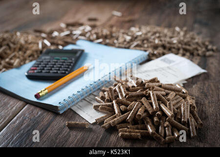 Die Berechnung der Haushalt Heizkosten. Holz- pellets, biomasse, effiziente, umweltfreundliche und wirtschaftliche Heizung, nachhaltigen und erneuerbaren en Stockfoto