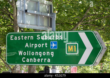 Grüne Straße Richtung Verkehrszeichen in Sydney Australien zum Flughafen und den östlichen Vororten Stockfoto