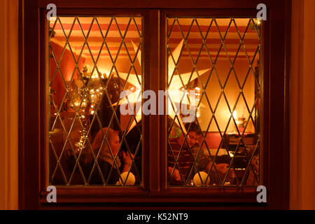 Beleuchtete weihnachten Stern hinter dem Fenster einer Taverne in Erbach im Odenwald, Hessen, Deutschland Stockfoto