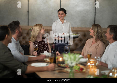 Kellnerin Speisen an Kunden im restaurant Stockfoto