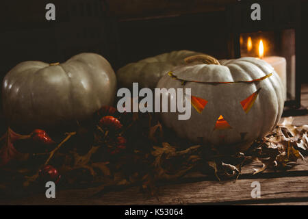 Weiß jack o Laternen mit Herbstlaub auf hölzernen Tisch Stockfoto