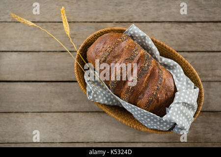 Ansicht von oben von braunem Brot im Korb auf hölzernen Tisch Stockfoto