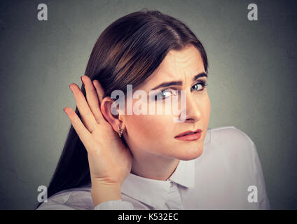 Frau mit einem Hörverlust schröpfen ihre Hand hinter dem Ohr mit dem Kopf in Richtung Kamera zu versuchen und der zur Verfügung stehenden Sound verstärken Stockfoto