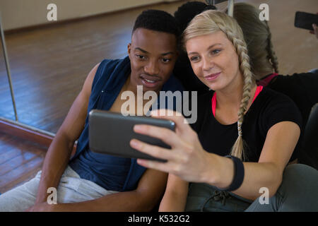 Junge Tänzerin mit männlichen Freund unter selfie durch Spiegel im Studio Stockfoto