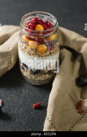 Joghurt mit Granatäpfel und goldenen Beeren in Glas Glas Stockfoto
