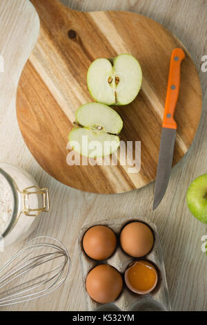 Ansicht von oben von Granny Smith Apfel auf schneidebrett von ei Karton auf Tisch halbiert Stockfoto