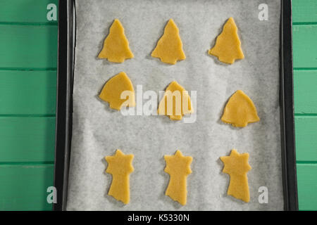 In der Nähe verschiedener Form roh Cookies in Backblech auf hölzernen Tisch Stockfoto