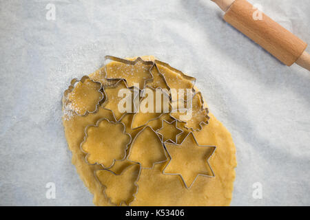 Ansicht der verschiedenen Form Plätzchenausstecher auf gewalzten Teig auf wachspapier Stockfoto