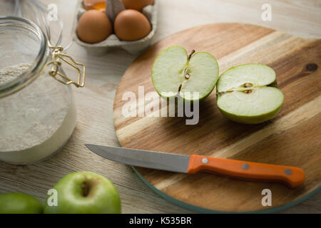 Hohe Betrachtungswinkel von Granny Smith Apfel auf schneidebrett von ei Karton auf Tisch halbiert Stockfoto