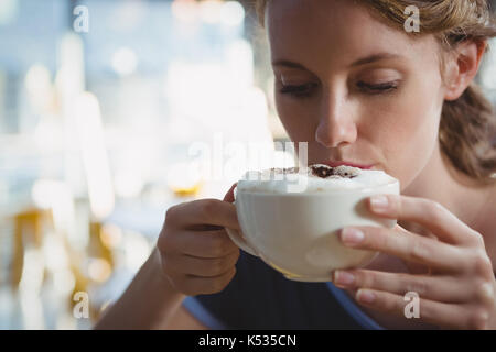 Close-up junge Frau trinkt Kaffee im Cafe Stockfoto