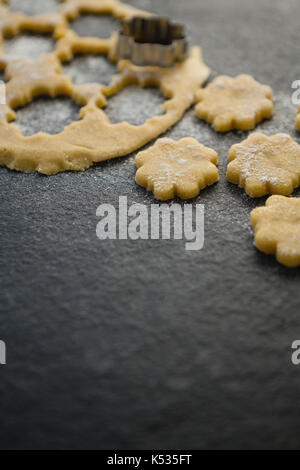 Nahaufnahme von Blume Plätzchenausstecher auf Teig am Tisch Stockfoto