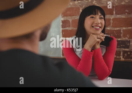 Glückliche junge Frau mit Freund im Cafe sitzen Stockfoto