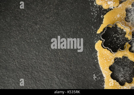 Blume Plätzchenausstecher auf Teig am Tisch Stockfoto