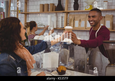 Lächelnd Eigentümer Kaffee zu Frau im Cafe Stockfoto