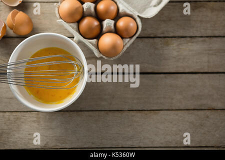 Ansicht von oben von Eiern in der Schale und Karton auf Holz- Tabelle Stockfoto