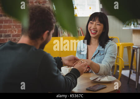 Mann, Ring auf glückliche junge Frau Finger im Cafe Stockfoto