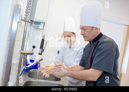 Frau und Mann die Hände waschen am Waschbecken Stockfoto