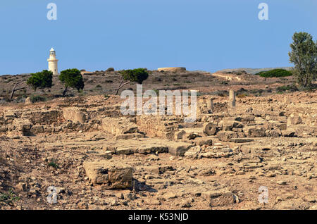 Weißen Leuchtturm auf dem Hintergrund der Berge, uralte Ruinen und der Archäologische Park von Paphos, Zypern. Stockfoto