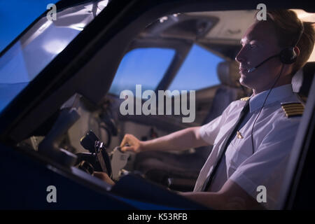 Hübscher junger Mann Pilot Flugzeug aus dem Fenster gesehen Stockfoto