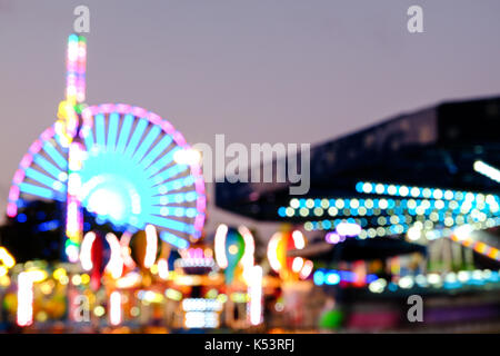 Abstrakte verschwommene Lichter des Riesenrads und andere Attraktionen bei Nacht. Minnesota State Fair - die größte State Fair in den USA. August 2017 Stockfoto