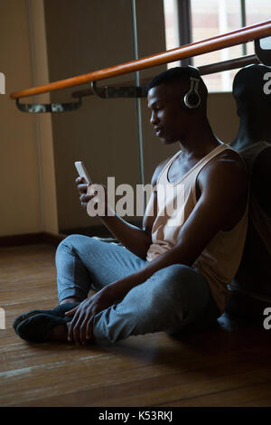 Ballerino mit Handy im Studio Stockfoto