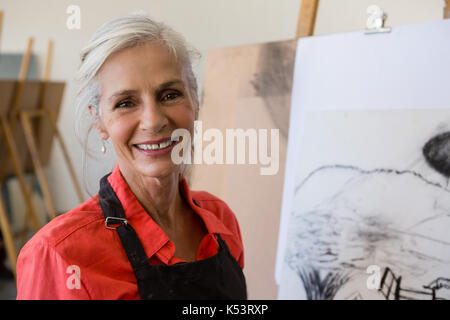Close up Portrait von gerne ältere Frau, die von der Malerei Stockfoto