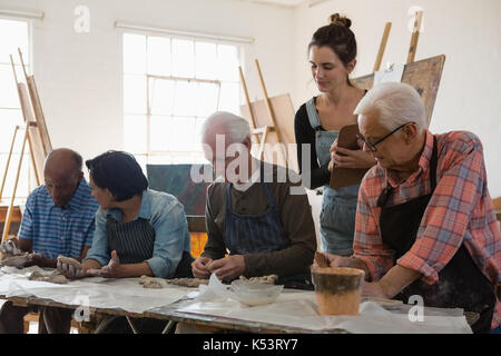 Frau Prüfung älterer Menschen, Ton Produkt bei Tisch und in der Kunst der Klasse Stockfoto