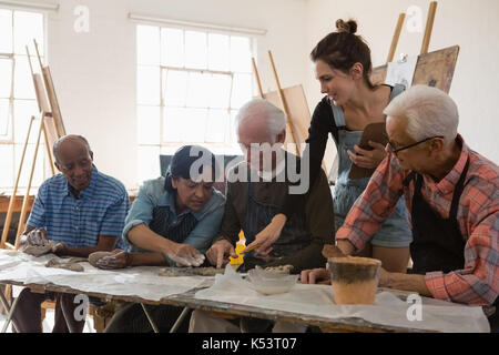 Frau Unterstützung älterer Menschen, Ton Produkt bei Tisch und in der Kunst der Klasse Stockfoto