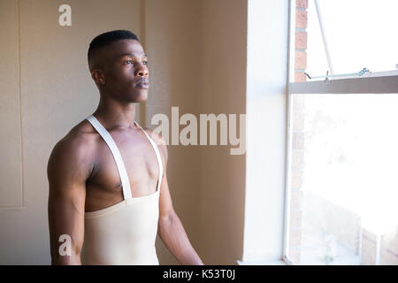 Stattliche ballerino Blick durch das Fenster Stockfoto