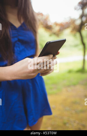 Im mittleren Abschnitt der Frau mit Handy im Wald Stockfoto