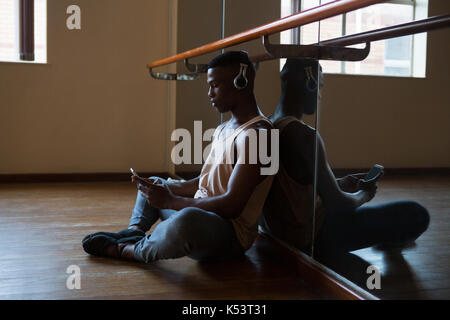 Ballerino mit Handy im Studio Stockfoto