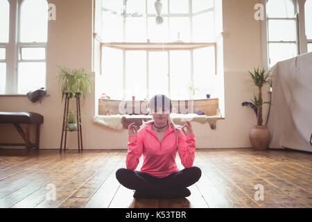 Junge Frau Yoga auf Parkett im Studio Stockfoto