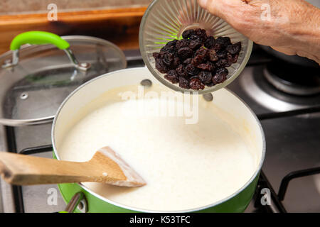 Milchreis mit cinamon und Rosinen Zubereitung: Rosinen hinzufügen Zu den gekochten Reis Stockfoto