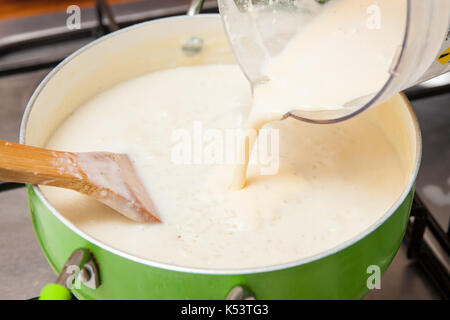 Milchreis mit cinamon und Rosinen Zubereitung: Hinzufügen von Milchpulver zu den gekochten Reis Stockfoto