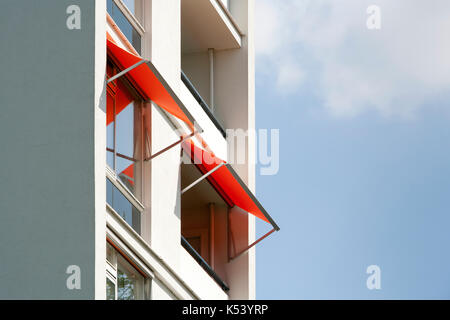 Orange Markisen auf einem weißen Apartment Block Stockfoto