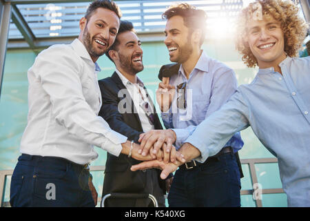 Portrait von vier glückliche Geschäftsleute halten sich an den Händen Stockfoto