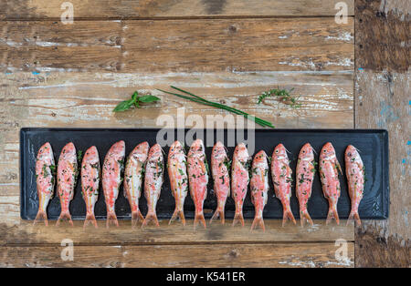 Viel von der Rotbarbe Fisch am Grill auf alten hölzernen Booard zu Grill Stockfoto