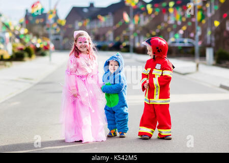 Kinder auf Halloween Trick oder Festlichkeit. Kinder in Halloween Kostüme mit Süßigkeiten Taschen wandern in eingerichtet Stadt Nachbarschaft Süßes oder Saures. Baby- und Pr Stockfoto