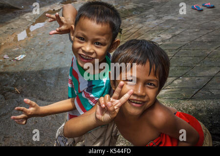 SIHANOUKVILLE, Kambodscha - 7/20/2015: Zwei Jungen spielen in den Straßen von ihrem Fischerdorf. Stockfoto