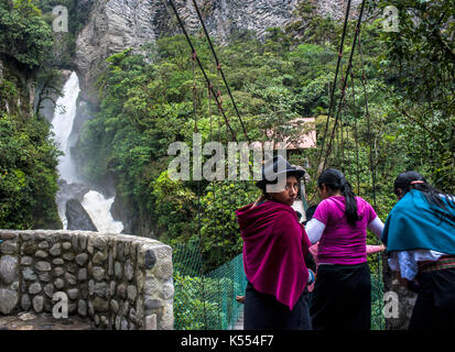 Banos de Agua Santa, Cascades route, Ecuador - Mai 1, 2012: indigene Frauen über die Brücke zu Fuß unter Devil's Cauldron Wasserfall (Spanisch: Pailon Stockfoto