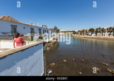 Touristen bewundern Landschaft und typische Häuser am Ufer des Flusses Gilão in dem Dorf Tavira Faro Algarve Portugal Europa Stockfoto