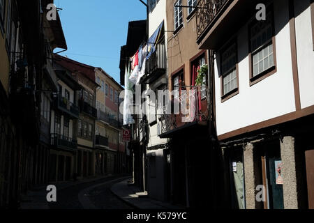 Waschen hängt in der Luft außerhalb eines Fensters in einer Seitenstraße in Guimaraes, Portugal, 22. August 2017. © Johannes Voos Stockfoto
